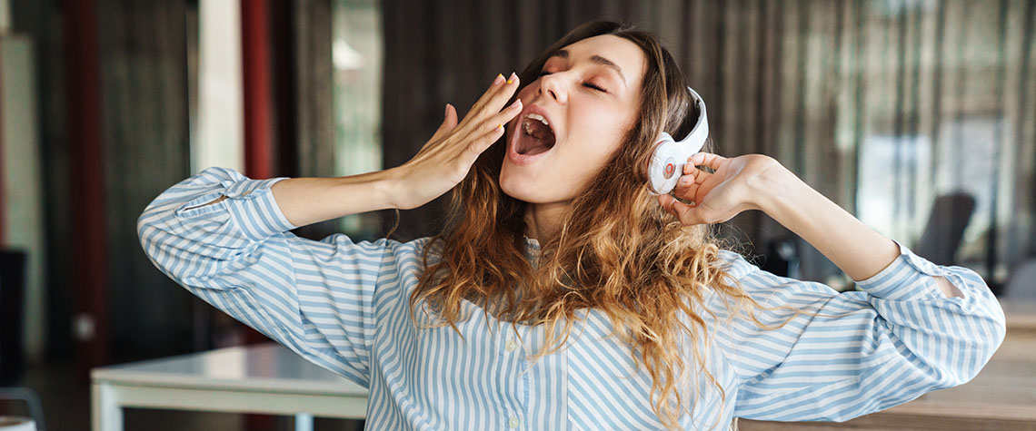 Image of sleepy woman listening music with headphones and yawning. bus albino penis envy shrooms online.