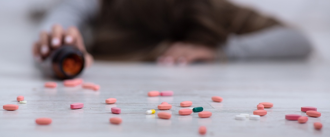 Young woman lying on floor with tablets scattered. order magic mushrooms psilocybin online.