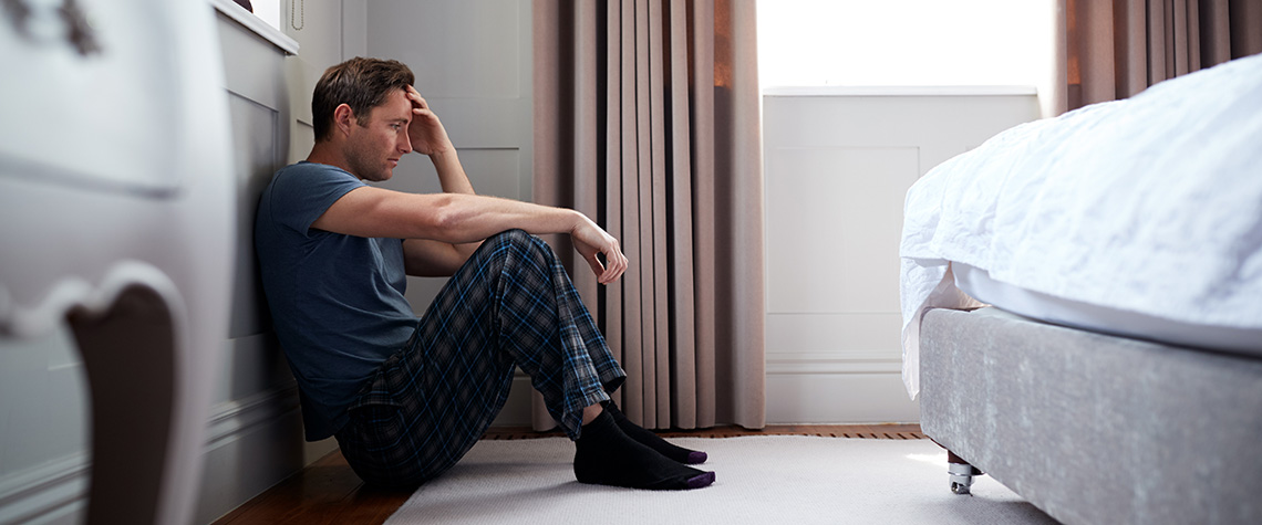 Depressed Man Sitting On Floor. magic mushrooms and mental health benefits. buy shrooms online.